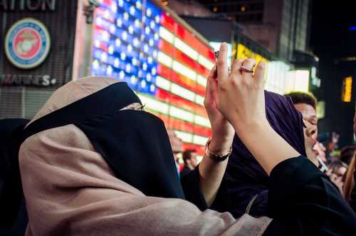 Kvinna i burka fotar med sin telefon